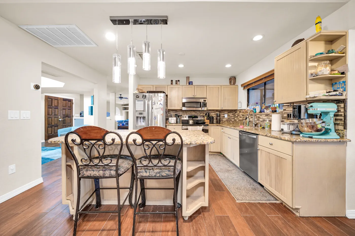 Two stools at the kitchen island under pendant lights.