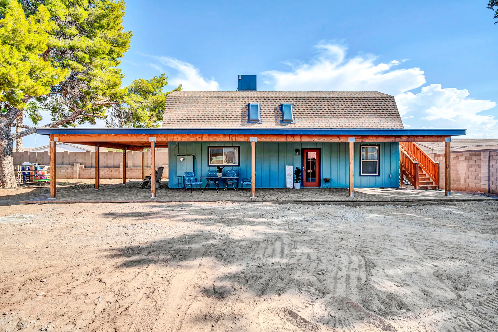 The barn apartments and their covered porch, seen across the yard on a clear day.